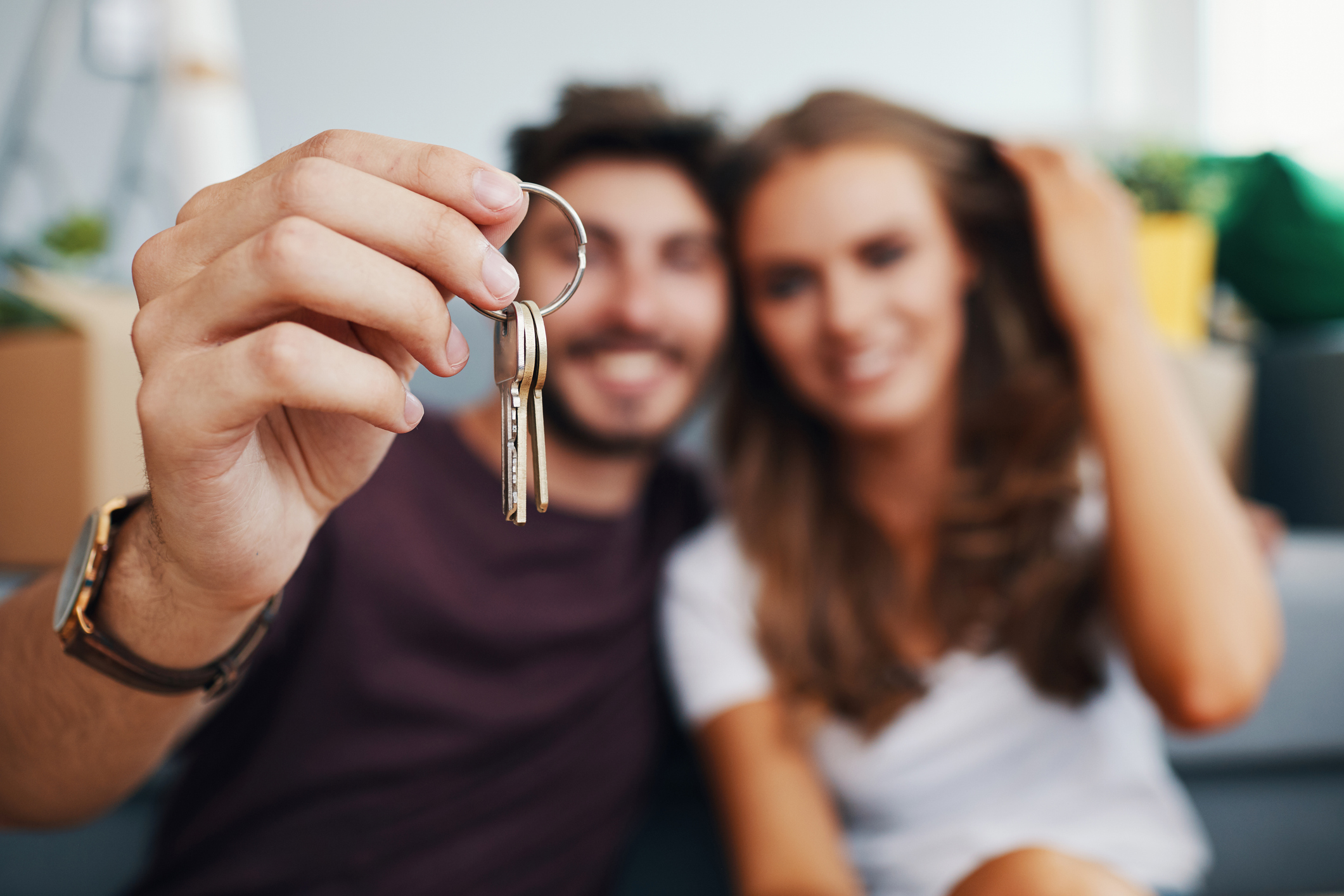 Closeup of couple showing keys to new apartment